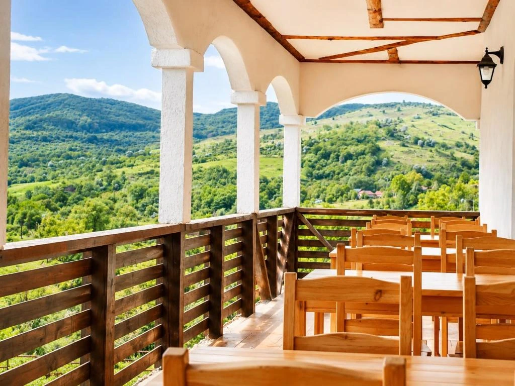 Terasă cu coloane arcuite și vederi panoramice spre munți
